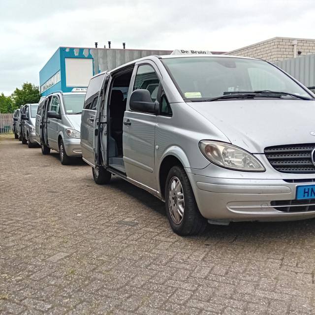 Het wagenpark van Taxi de Bruin: zilverkleurige luxe taxibusjes op de standplaats